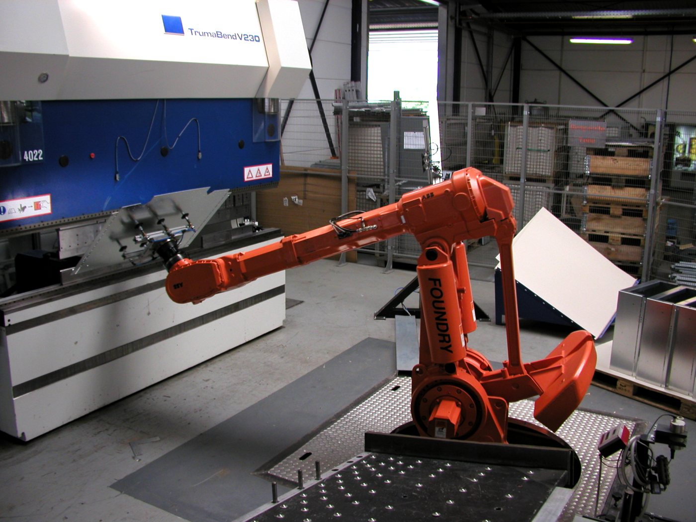 Industrial robot arm feeding a press brake